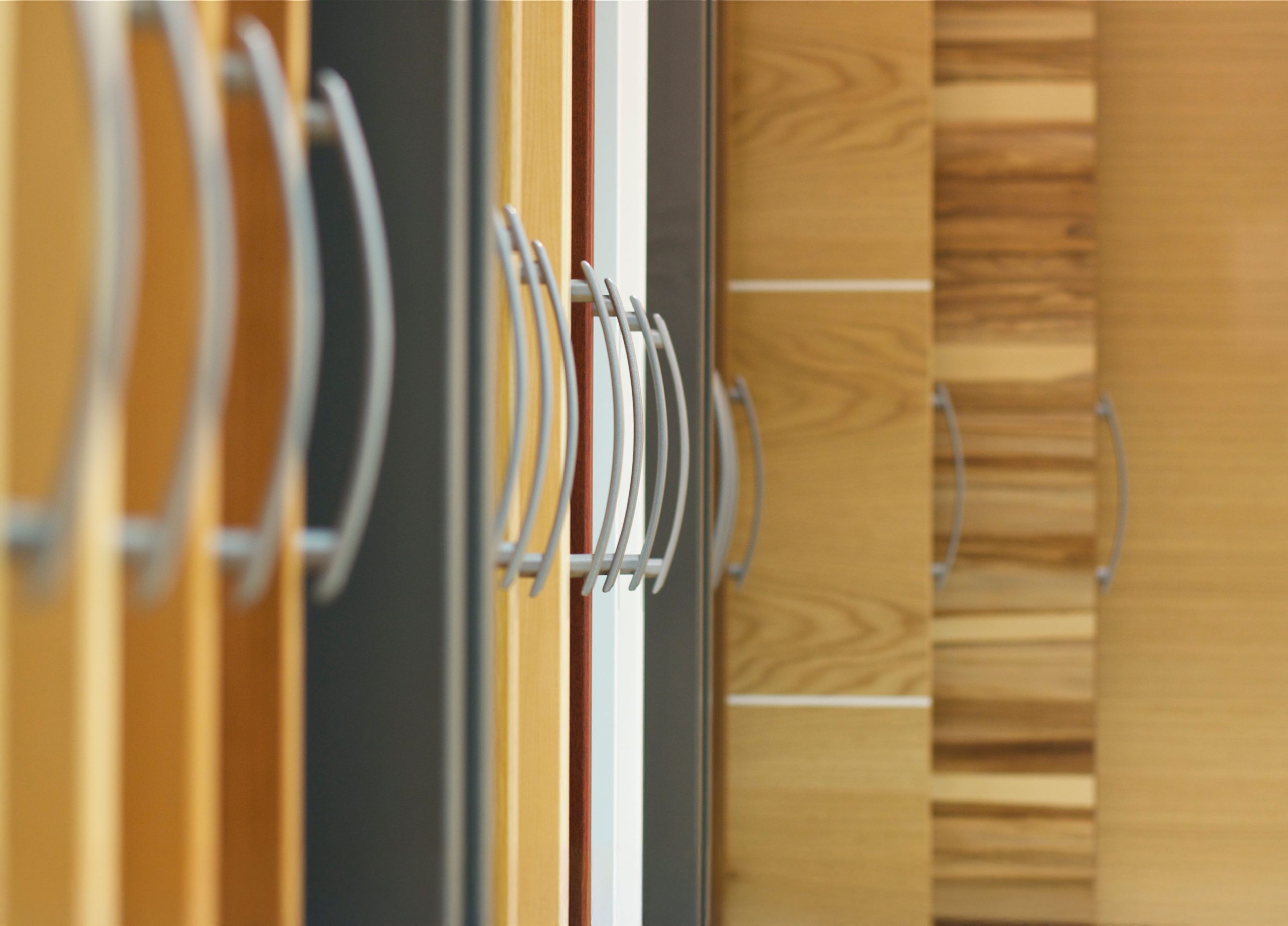Nahaufnahme von Holzschrankt&uuml;ren mit modernen Griffen im Fertighaus Bemusterungszentrum von WOLF Haus in Scharnstein.
