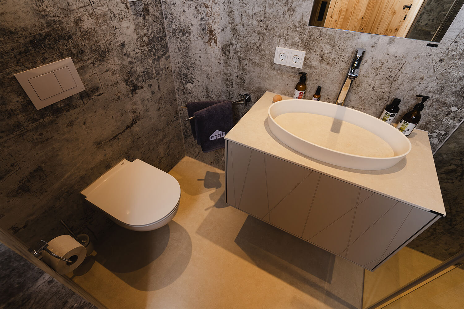 Modernes Badezimmer im individuell konfigurierten WOLF Tiny Haus mit freistehendem Waschbecken, WC, Armaturen und stilvoller Steinoptik